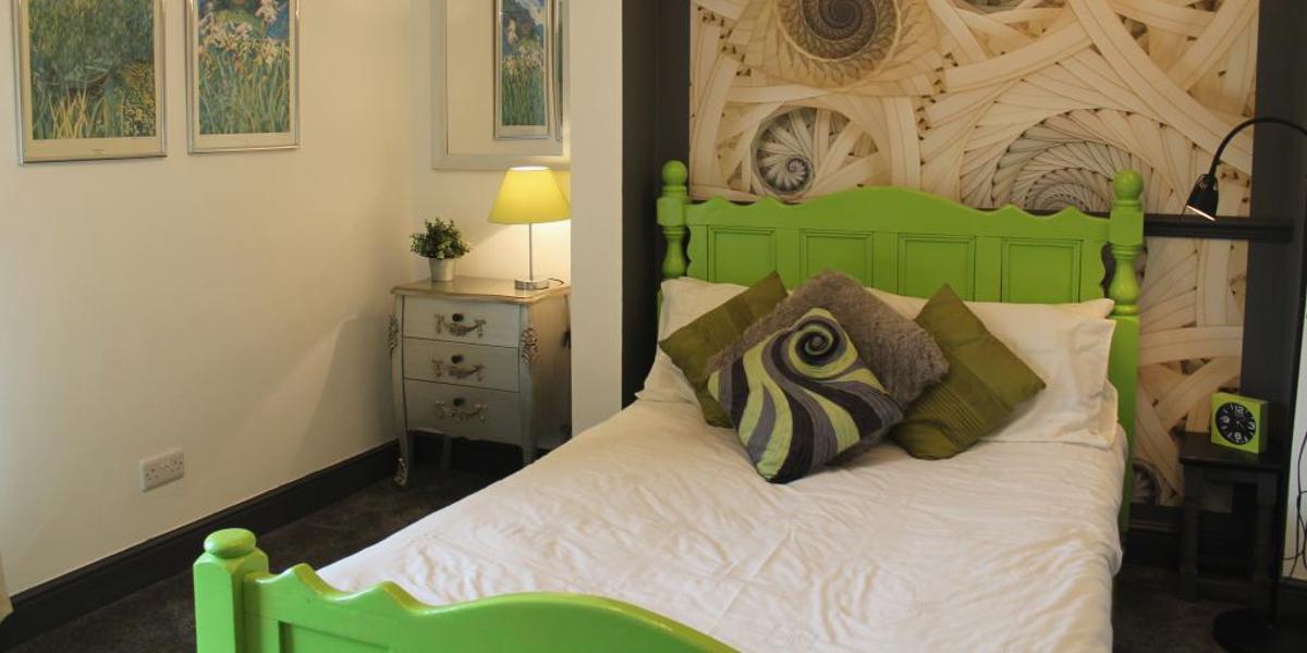 Main image: Spiral themed bedroom at The Myriad. Spiral themed bedroom with lime green bed frame at The Myriad.