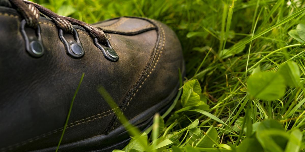 Close-up of hiking boot laying on grass.