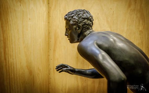 Harris statue of man inside wooden storage box.