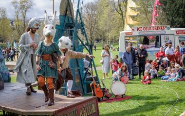 A group of entertainers dressed in medieval clothing and hats that look like animals on a stage