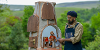 A La Puppet Carte performer interacts with a clay puppet that is in a small house