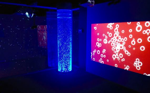 The Space Centre's Sensory Room 3 featuring a blue cylindrical bubble tank and bubble wall projections