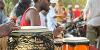 Close up of African people playing on brightly coloured drums