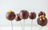 A handful of small balls of cake covered in chocolate icing and various sprinkle toppings called Cake Pops