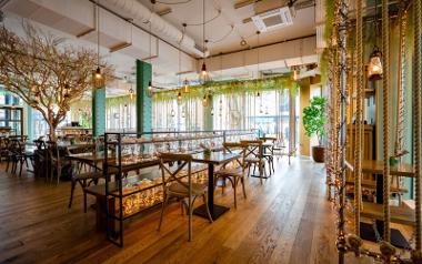 The interior of Mowgli Street Food with hanging lamps, leafless tree, and swinging benches