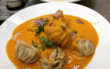 A plate of Nepali Jhol momo dumplings in a soup