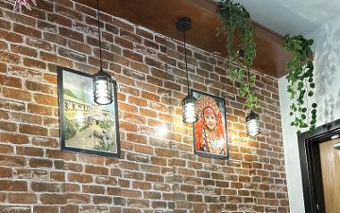 Two picture frames lit up on a wall inside Mitho Momo