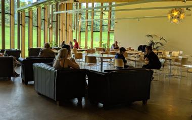 A group of people sat at tables inside the Pavilion Café