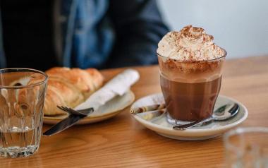 A hot chocolate with whipped cream in a glass mug, and a pastry from Town House Coffee