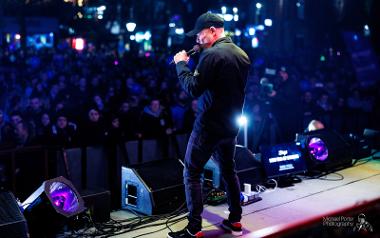 A singer performing a song on stage to a crowd at Preston Christmas Lights Switch On 2022