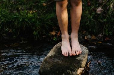 Child stood on stepping stone close up