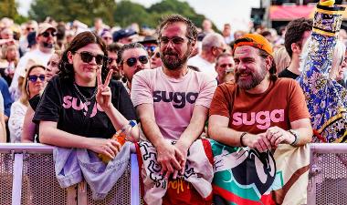 People wearing Suga t-shirts in crowd