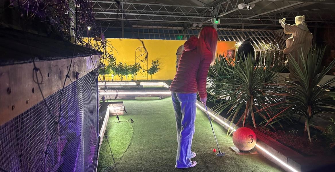 Woman playing crazy golf at Flower Bowl