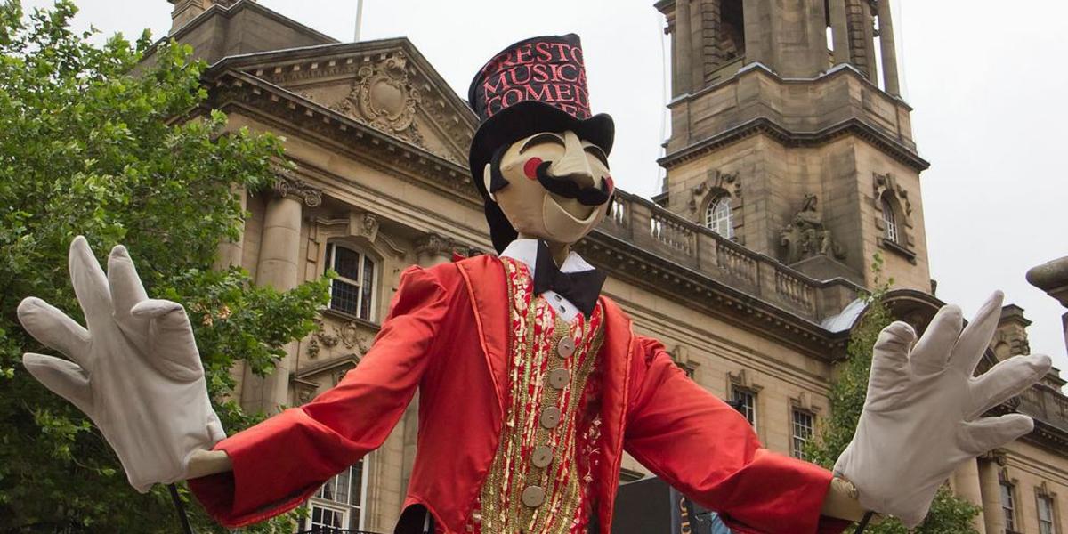 Giant puppet of a circus man in a Guild procession by the Preston Sessions House.