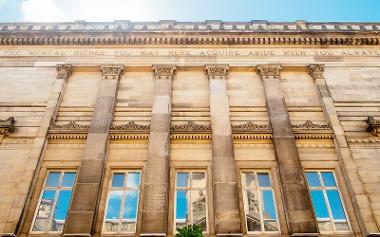 Quote on the side of the Harris building reading "The mental riches you may here acquire abide with you always".