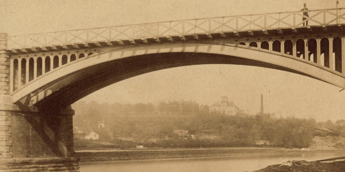 Old sepia photograph of a man standing on a bridge crossing the River Ribble to Avenham and Miller Parks.