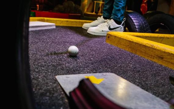 Close-up of putt being made in Level Preston's crazy gold course.