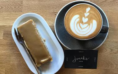 Coffee and cake and Jonah's loyalty card on table.