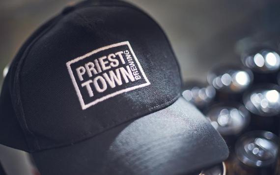 Black cap with Priest Town Brewing logo on front.