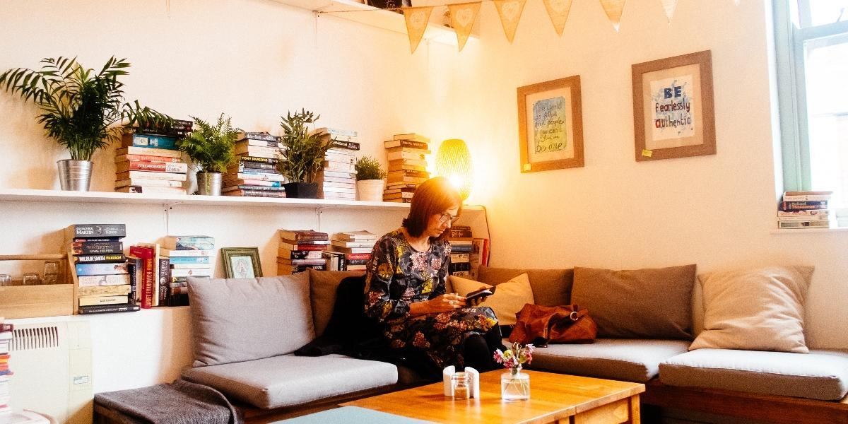 Woman sat inside Town House Coffee and Brew Bar, surrounding by books.