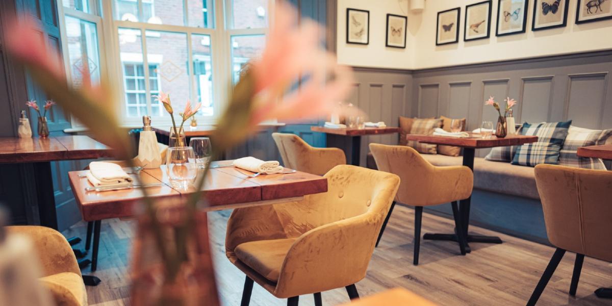 Yellow velvet chairs and bench seating in Aven Restaurant's dining area.