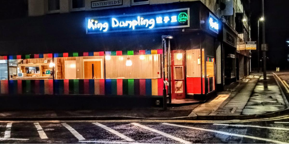 Outside King Dumpling restaurant, lit up at night.