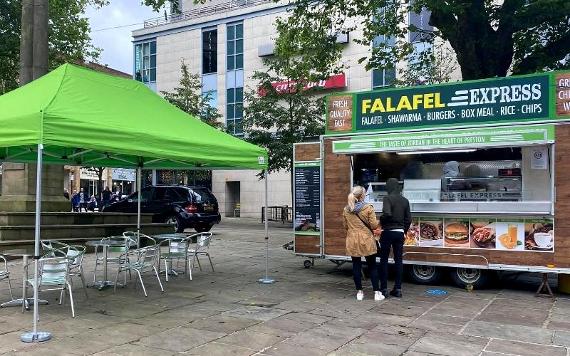 Queue for food and seating area around Falafel Express on Preston Flag Market.