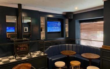 Blue comfy seating and fireplace inside The Northern Way bar.