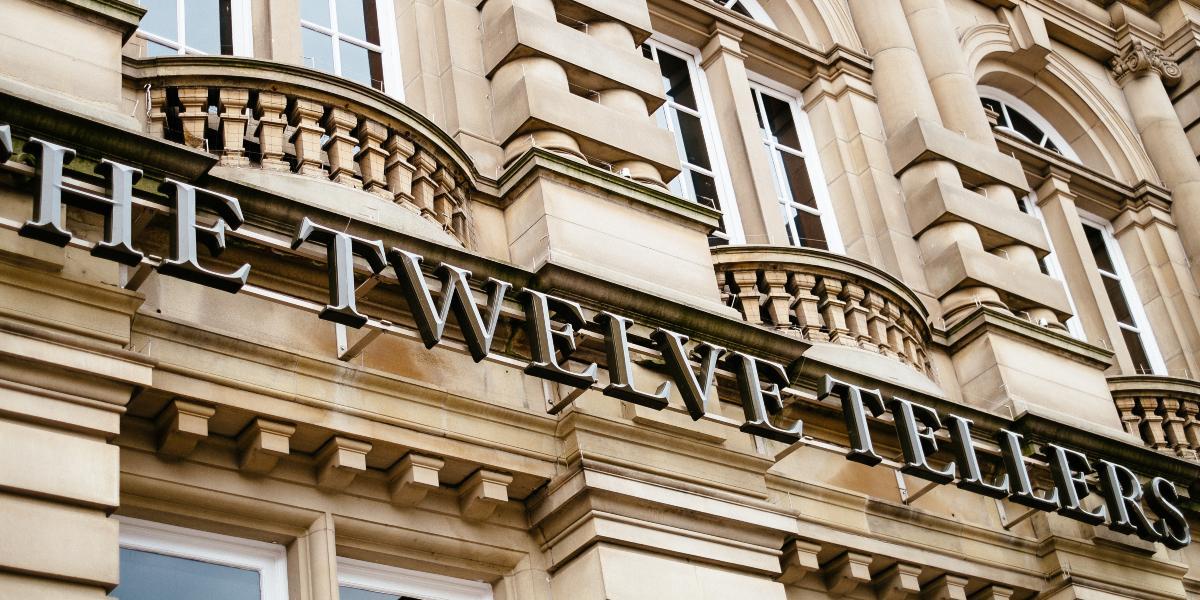 Main image: Close-up of The Twelve Tellers metal sign outside venue. Close-up of The Twelve Tellers metal sign outside venue.