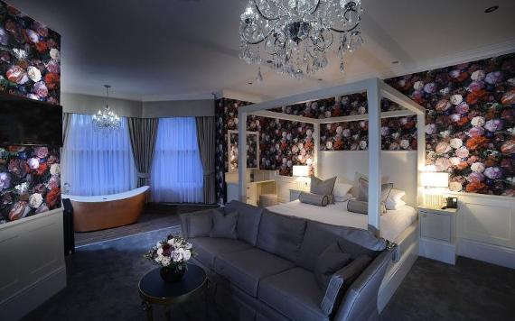 Four poster bed with in Bartle Hall hotel room with flowered walls.