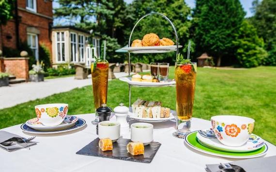 Afternoon tea arranged on table in Bartle Hall Country Hotel's grounds.