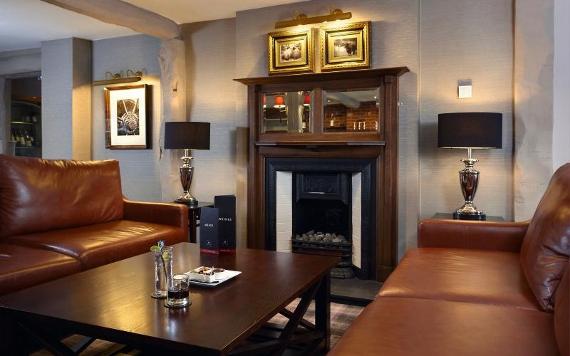 Leather sofas by a fireplace in Macdonald Tickled Trout lounge area.