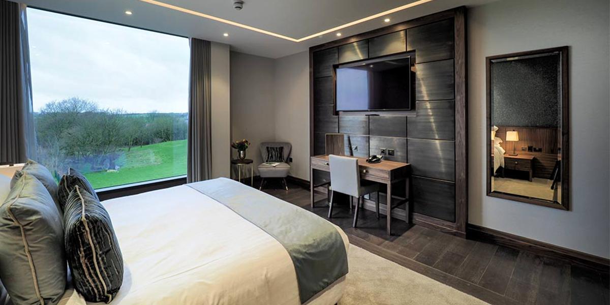 Large hotel room at Mill Farm, with green views from window.