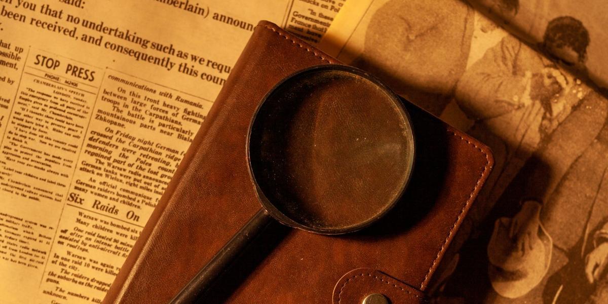 Main image Lancashire Family History &Heraldry Society Magnifying glass on notebook and newspapers.