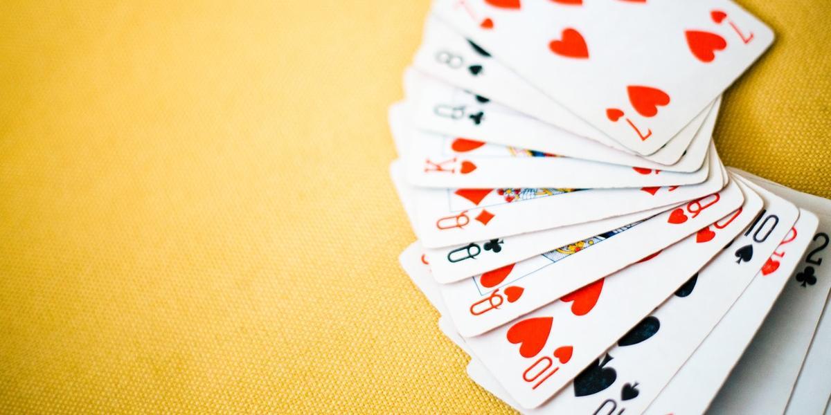 Deck of cards spread over yellow cloth.