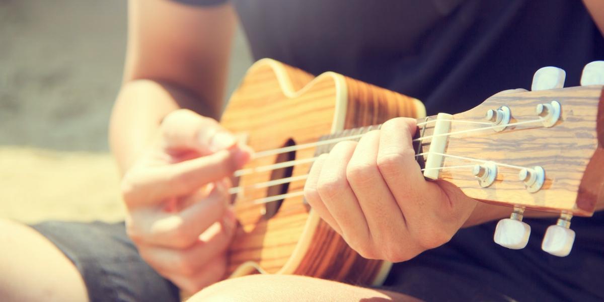 Main image Ukulele Strummers Man playing Ukulele in the sun.