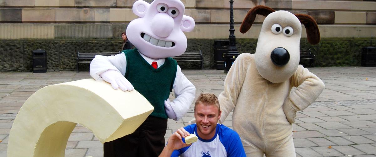 Wallace and Gromit standing with Freddie Flintoff on Preston Flag Market.