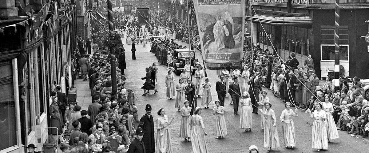 Women walking with banner in former Preston Guild procession. 