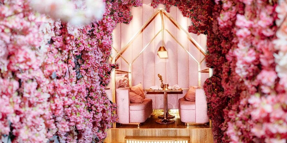 Artificial pink flowered walls and pink and gold dining booth inside Saladishy restaurant.